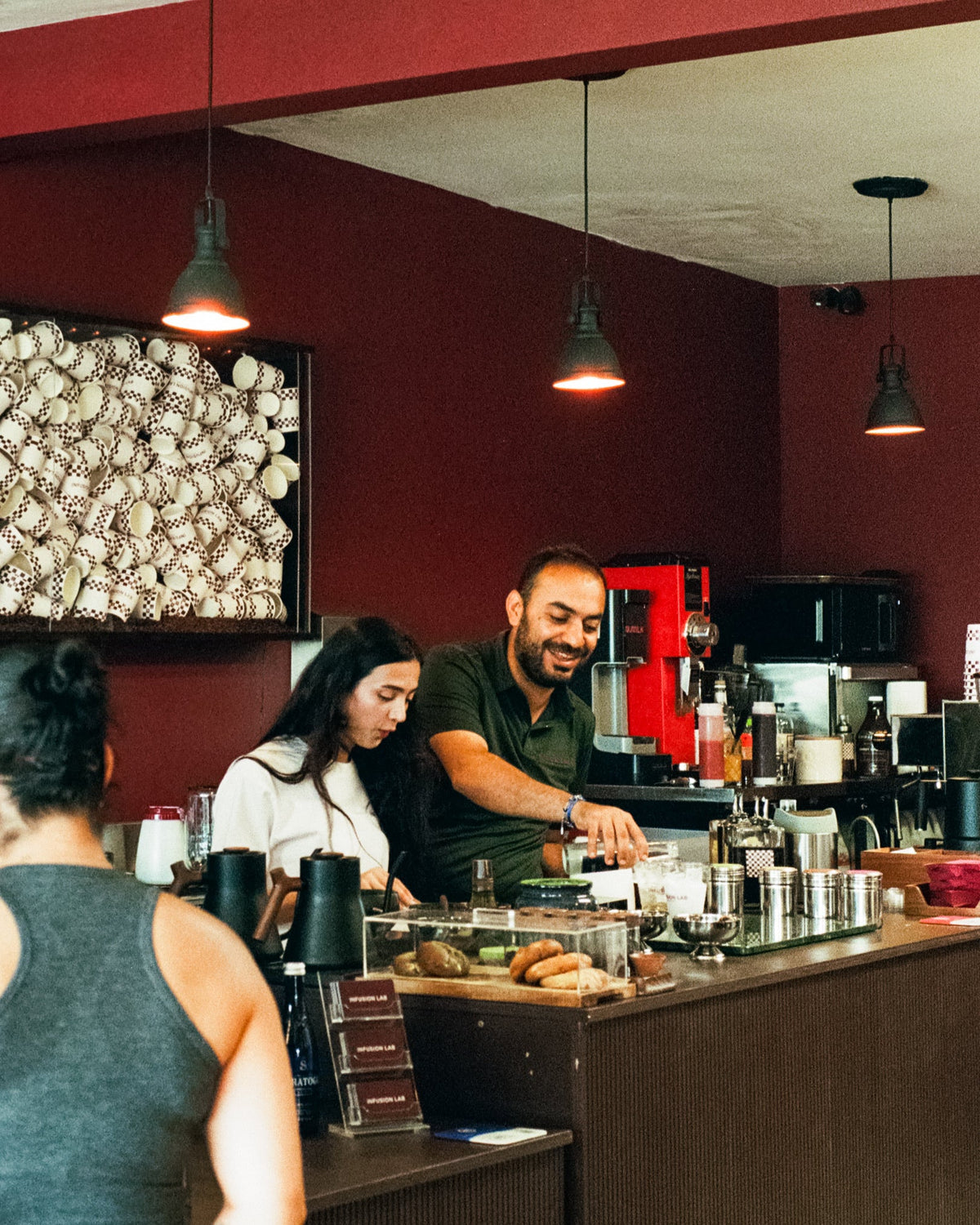 The Infusion Lab team preparing drinks and welcoming a guest at the coffee bar