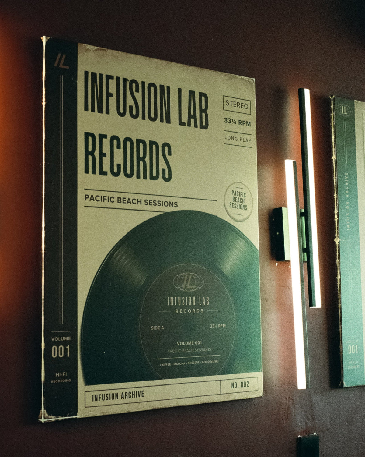 A framed Infusion Lab Records poster on a burgundy wall